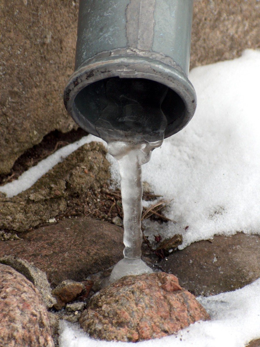Pipe with frozen water in snow